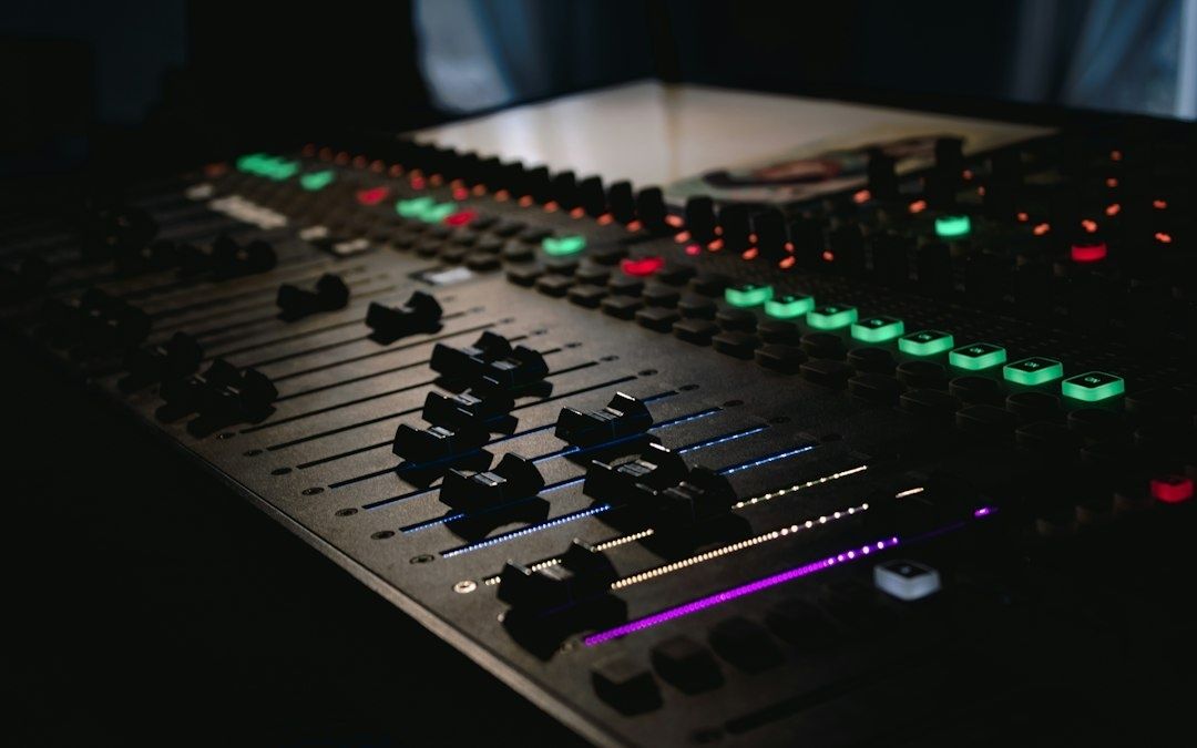 Console de mixage audio éclairée, avec faders et boutons colorés