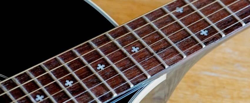 Gros plan sur une touche de guitare en palissandre
